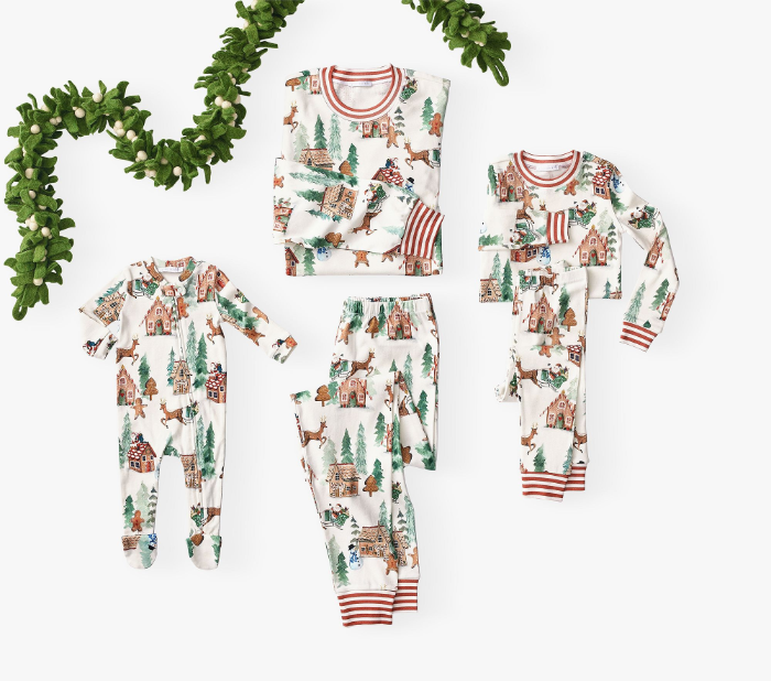matching pajamas flat lay featuring adult size, baby onesie, and kid size. The pjs are white with a gingerbread print with a collar and cuffs in candy-cane stripes.
